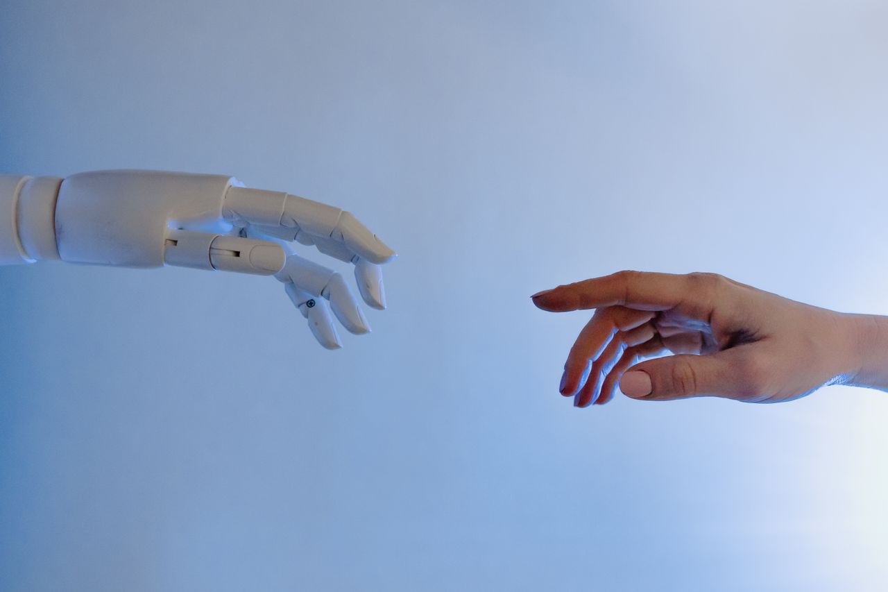 portfolio-02 A human hand reaching towards a robotic hand symbolizing technology and connection.
