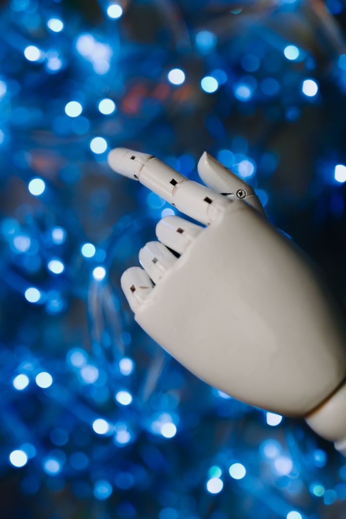 why-choose-us Close-up of a robotic hand with glowing blue bokeh background, symbolizing advanced technology.